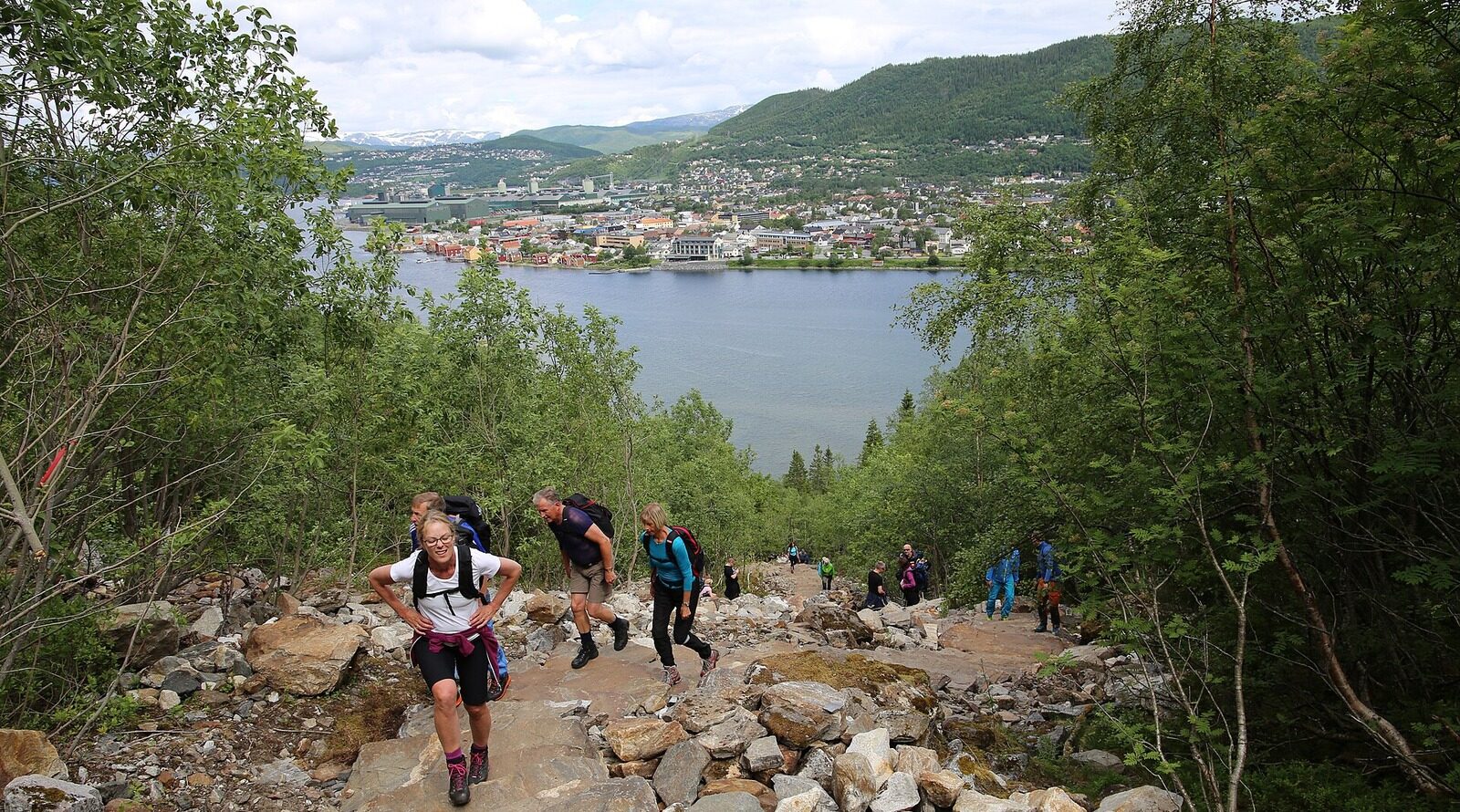 Helgelandstrappa – turyści na kamiennych schodach nad Mosjøen i fiordem Vefsna